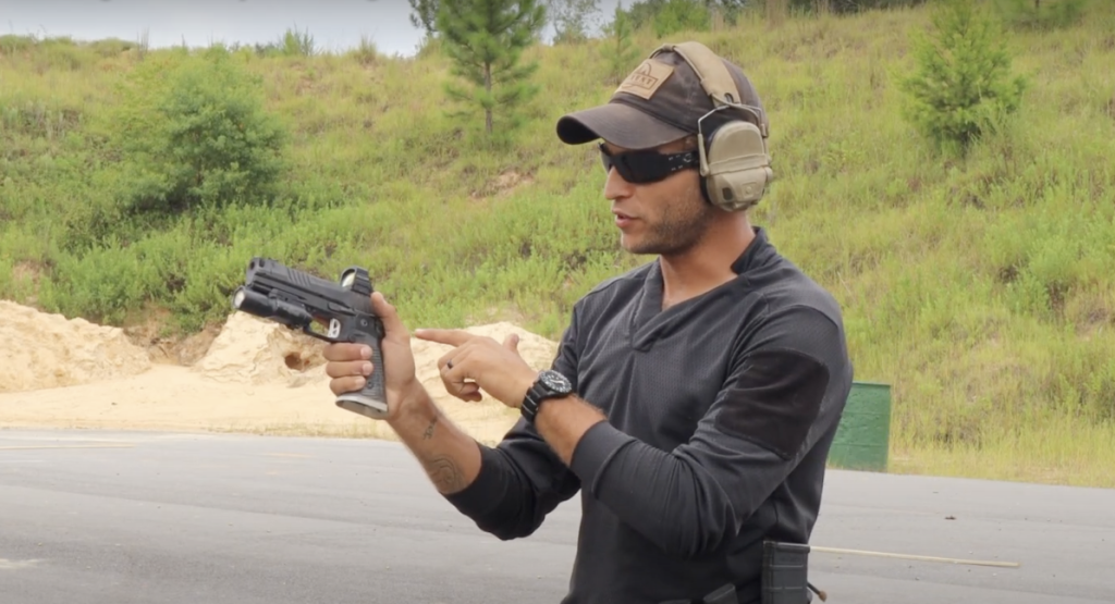Shooting range instructor teaching hand gun safety tips